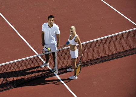 Happy young couple play tennis game outdoor man and woman