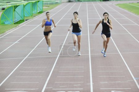 Girls running on athletics race track