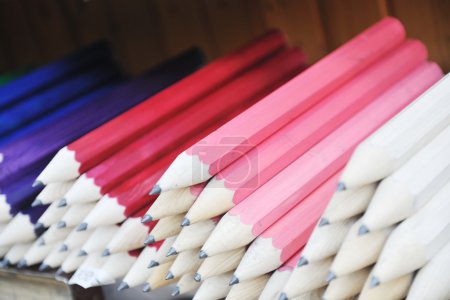 Big wooden colored pencil arranged outdoor for sale like souvenir