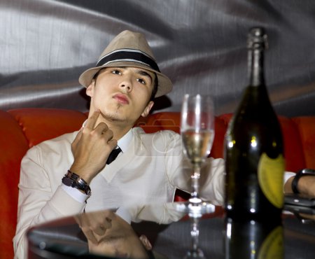 Handsome man drinking champagne in night club