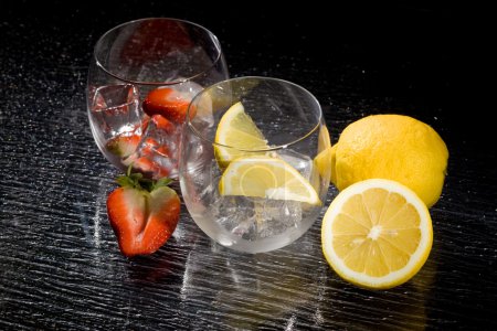 photo of fresh strawberries and lemons on ice cubes