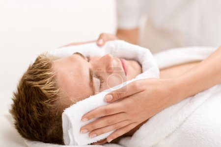 Male cosmetics - luxury spa treatment receiving facial massage