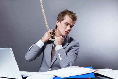 A young businessman tightens the noose on