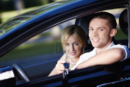 Young couple in the car with the keys of the car