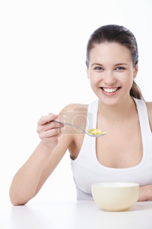 A pretty young girl has corn flakes on a white background