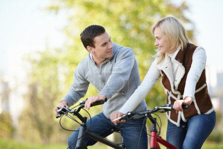 Attractive couple on bicycles looking at each other