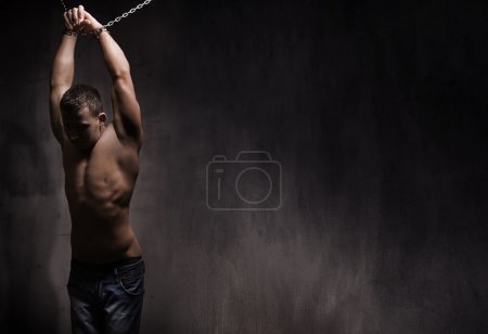 Young male model well build with chains over his arms