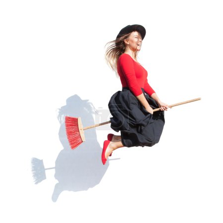 Happy young witch flying on a broom