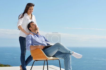 Couple at balcony with computer