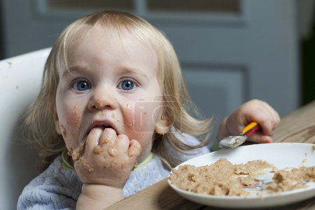 Baby eats porridge spoon