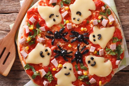 pizza for Halloween with ham, cheese and olives close-up. Horizo