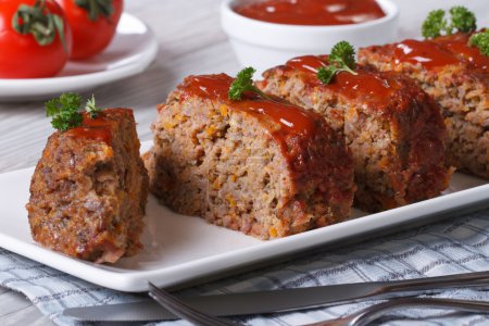 Sliced meat loaf with ketchup and parsley close-up