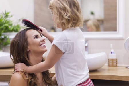 Girl doing hairdo for her mother