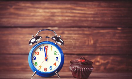 Alarm clock and cupcake.