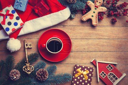 Cup of coffee with pine branch and christmas gifts on wooden bac
