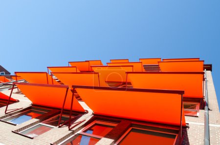 Flats windows with orange shade sail sun protection.