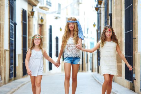 Kid girls walking hand in hand Mediterranean town