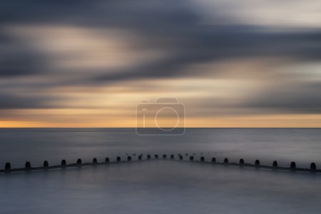 Beautiful long exposure vibrant concept image of ocean at sunset