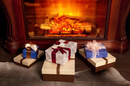 Christmas gift boxes near fireplace
