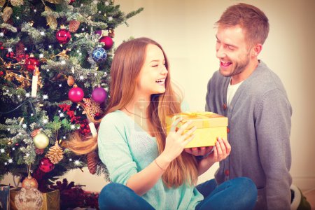 Couple with Christmas Gift at Home.