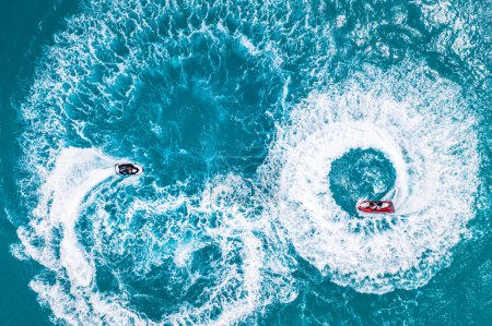 Aerial view of water extreme action sport, summer sea, close to luxury tropical resort . Fly board in ocean lagoon, freedom fun as summer recreational activity. Flyboard view from drone