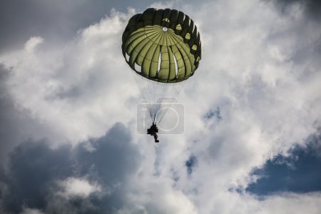 Parachutist in cloudy sky