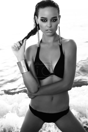 gorgeous sexy girl with dark hair posing on beach  