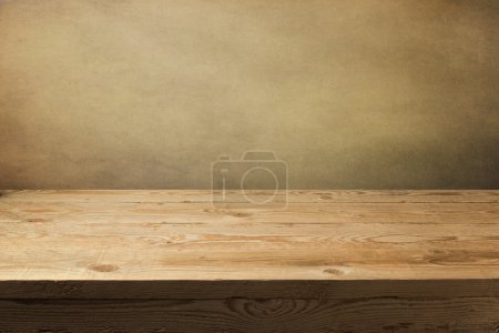 Wooden table over grunge wallpaper