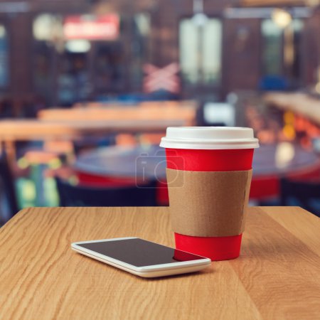 Paper coffee cup and smartphone