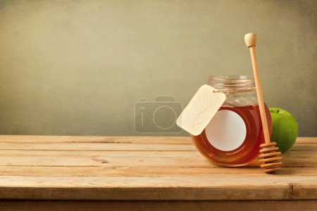 Honey and apple on wooden table with copy space