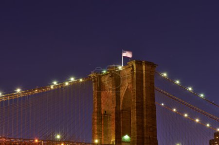 Brooklyn bridge with flag at night