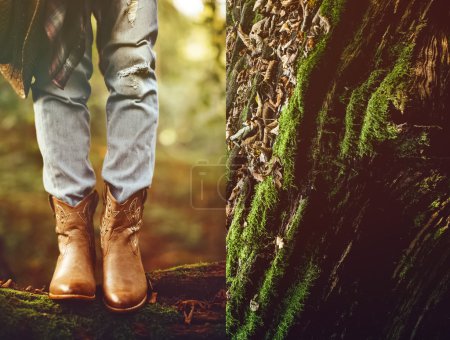 Autumn cowboy style. Cowboy boots in the woods