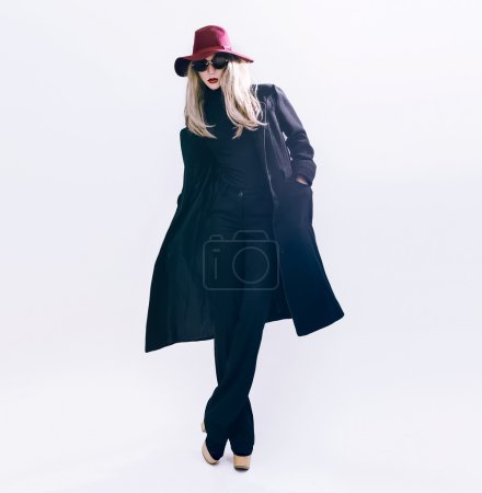 Fashion Glamorous blonde model in a black coat and hat. Fall win