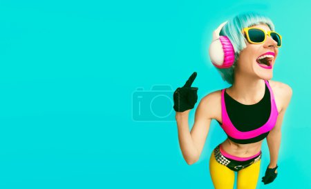 Glamorous fashion dj girl in bright clothes on a blue background