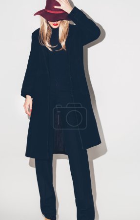 Fashion Glamorous blonde model in a black coat and hat. Fall win