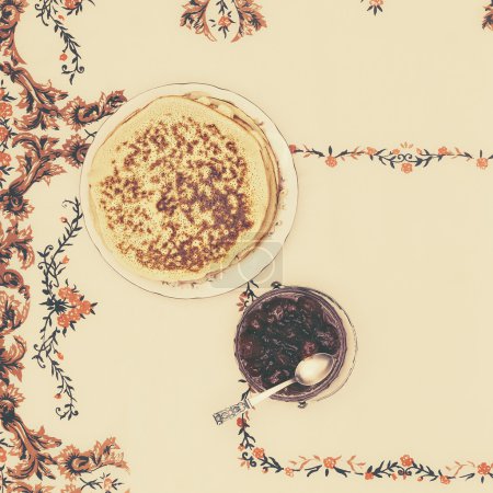 village pancakes with jam on a vintage tablecloth