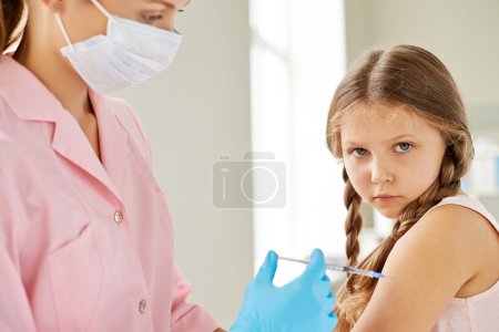 Nurse making injection to little girl