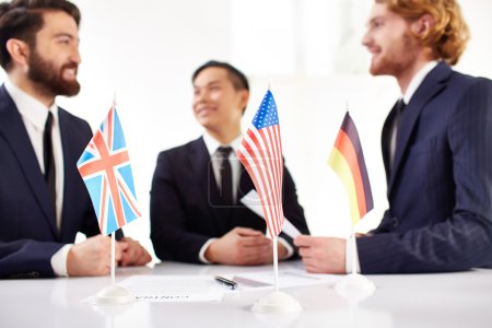 Business partners and American, British and German flags