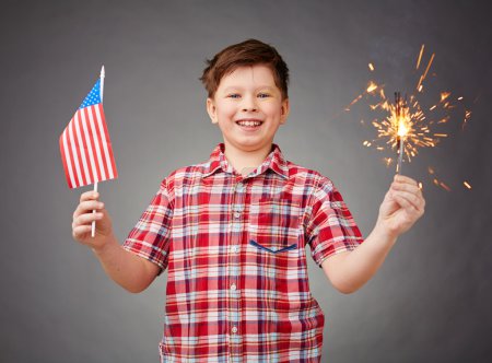 Boy holding bengal light and American flag