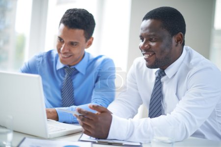 African-american businessman pointing at laptop