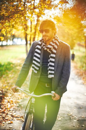 Man with bicycle in autumn park
