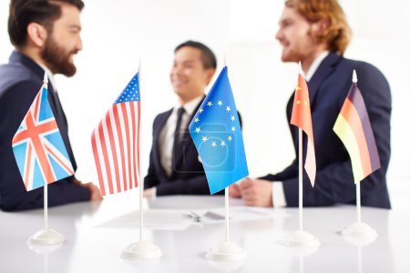 Business people with flags on negotiation table