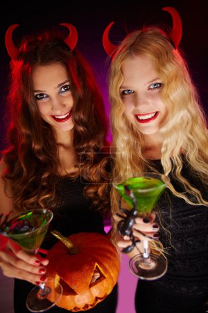 Halloween women toasting with cocktails