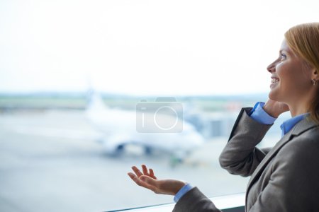 Businesswoman speaking on phone in airport