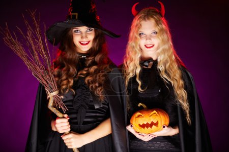 Two women with broom and pumpkin