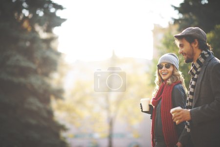 Couple drinking coffee in park