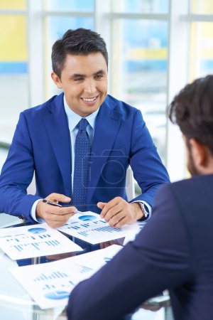 Businessman in suit looking at colleague