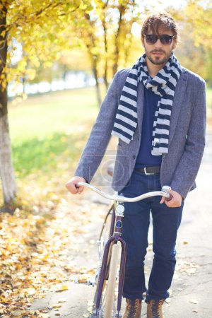 Man with bicycle in autumn park