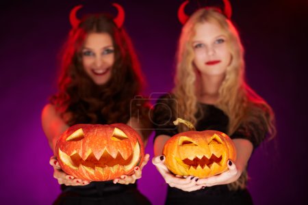 Halloween pumpkins held by females