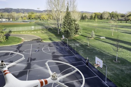 quadcopter drone flying over basketball court